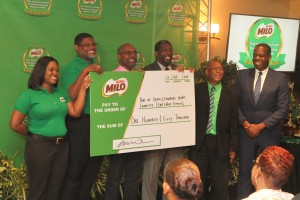 Photo 1 - Games delegates and NESTLÉ officials pose with $TTD 150,000 mock cheque, representing the Good Food, Good Life Company's contribution to the 2018 Kelvin Nanco Primary School Games